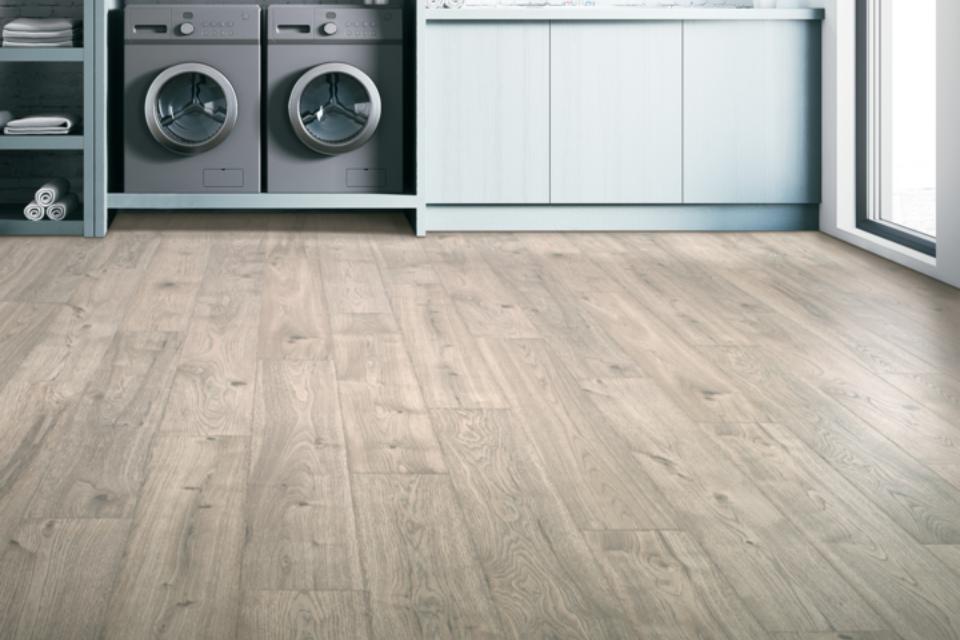 luxury vinyl flooring in laundry room with light blue cabinets.